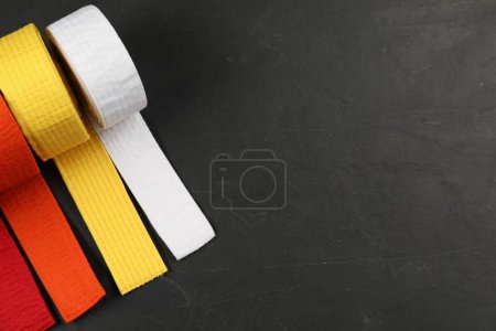 Photo for Colorful karate belts on gray background, flat lay. Space for text - Royalty Free Image
