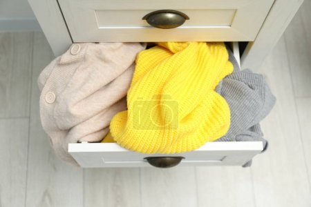 Photo for Cluttered chest of drawers indoors. Clothes in mess - Royalty Free Image
