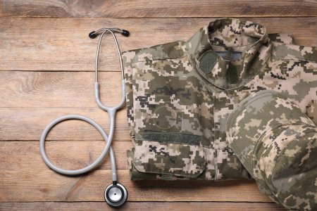 Stethoscope and military uniform on wooden background, flat lay