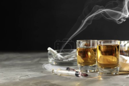 Photo for Alcohol and drug addiction. Whiskey in glasses and syringes on grey background, space for text - Royalty Free Image