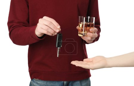 Téléchargez les photos : Homme avec verre de boisson alcoolisée donnant clé de voiture à la femme sur fond blanc, gros plan. Ne pas boire et conduire concept - en image libre de droit