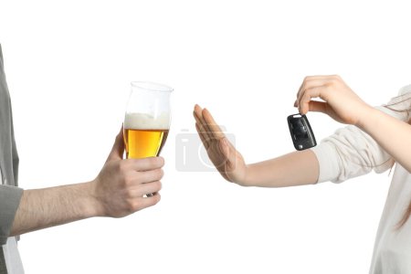 Téléchargez les photos : Femme avec des clés de voiture refusant l'alcool tandis que l'homme suggérant sa bière sur fond blanc, gros plan. Ne pas boire et conduire concept - en image libre de droit