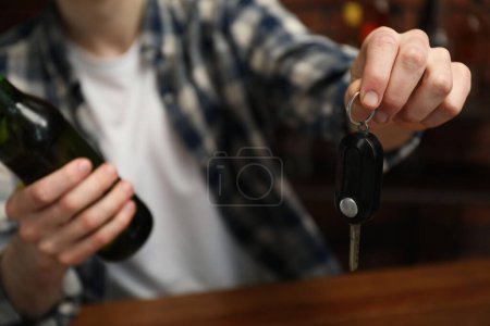Téléchargez les photos : Homme avec bouteille de bière et clés de voiture dans le bar, gros plan. Ne pas boire et conduire concept - en image libre de droit
