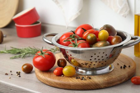Metallsieb mit Tomaten auf Arbeitsplatte in der Küche