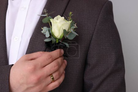 Foto de Novio con boutonniere sobre fondo gris claro, primer plano. Accesorio de boda - Imagen libre de derechos