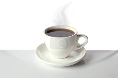 Foto de Café al vapor en taza sobre la mesa sobre fondo blanco - Imagen libre de derechos