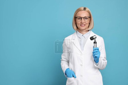 Téléchargez les photos : Dermatologist with dermatoscope on light blue background, space for text - en image libre de droit