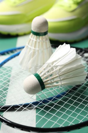 Photo for Feather badminton shuttlecocks and rackets on court, closeup - Royalty Free Image