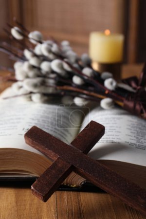 Cross and Bible on wooden table, closeup