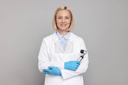 Téléchargez les photos : Happy dermatologist with dermatoscope on grey background - en image libre de droit