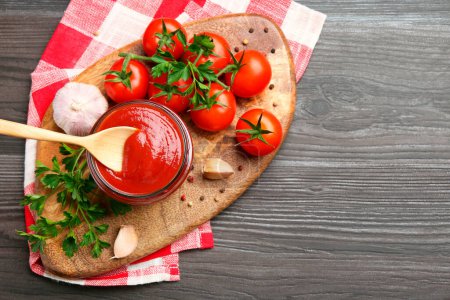 Photo for Tasty ketchup, fresh tomatoes, parsley and spices on grey wooden table, flat lay. Space for text - Royalty Free Image