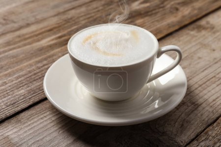 Foto de Café al vapor en taza sobre mesa de madera - Imagen libre de derechos
