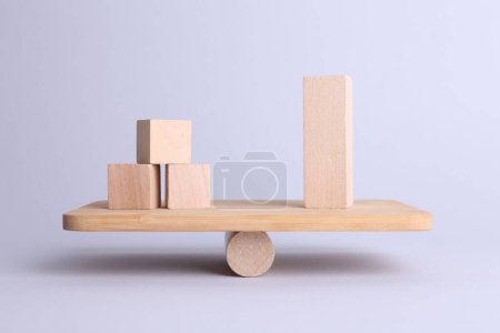 Equality concept. Seesaw scale with wooden blocks on light background