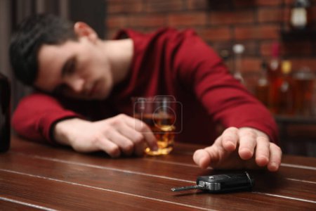 Téléchargez les photos : Un ivrogne cherchant des clés de voiture à table, gros plan. Ne pas boire et conduire concept - en image libre de droit
