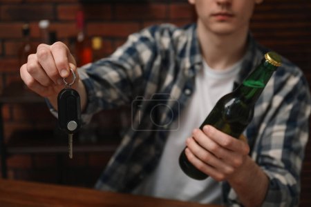 Téléchargez les photos : Homme avec bouteille de bière et clés de voiture dans le bar, gros plan. Ne pas boire et conduire concept - en image libre de droit
