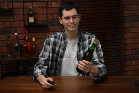 Téléchargez les photos : Homme souriant avec bouteille de bière et clés de voiture à la table dans le bar. Ne pas boire et conduire concept - en image libre de droit