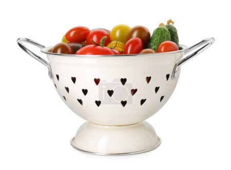Colador de metal con diferentes tomates y pepinos aislados en blanco