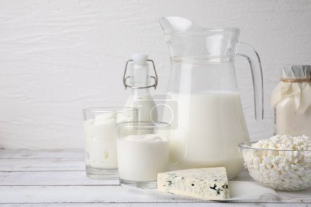 Téléchargez les photos : Différents produits laitiers frais sur table en bois blanc. Espace pour le texte - en image libre de droit