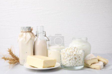 Different dairy products and spikes on white table