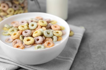 Photo for Tasty colorful cereal rings and milk in bowl on grey table, closeup. Space for text - Royalty Free Image