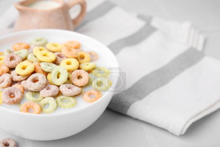 Photo for Cereal rings and milk in bowl on white table, closeup. Space for text - Royalty Free Image