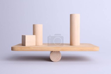 Equality concept. Seesaw scale with wooden blocks on light background