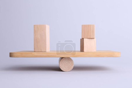 Concepto de igualdad. Escala de balancín con bloques de madera sobre fondo claro