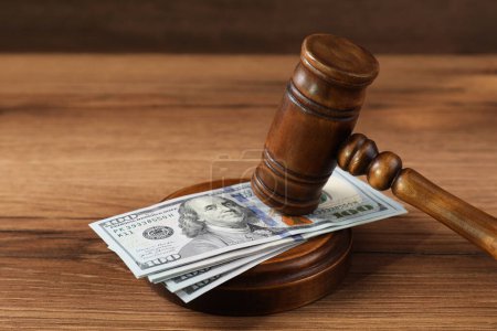 Richtergabel und Geld auf Holztisch
