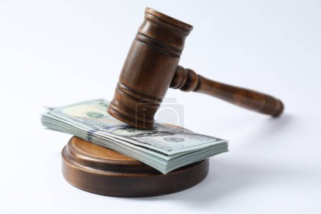 Law gavel with stack of dollars on white background