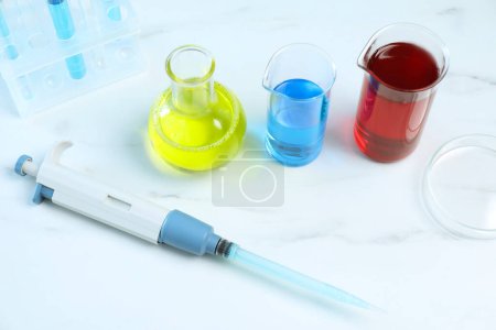 Photo for Laboratory analysis. Micropipette, petri dish and other glassware on white marble table - Royalty Free Image
