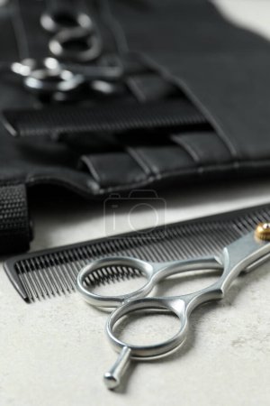 Hairdresser tools. Professional scissors, combs and leather organizer on white table, closeup