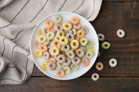 Photo for Cereal rings and milk in bowl on wooden table, top view - Royalty Free Image