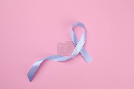 Journée internationale du psoriasis. Ruban comme symbole de soutien sur fond rose, vue de dessus