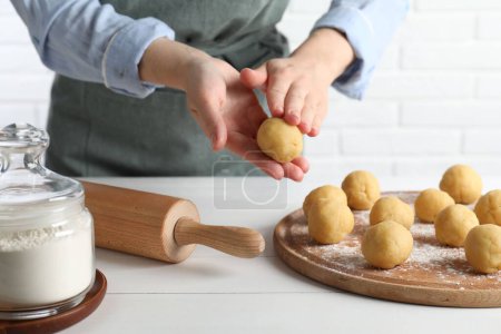 Shortcrust pastry. Woman making dough ball at white wooden table, closeup