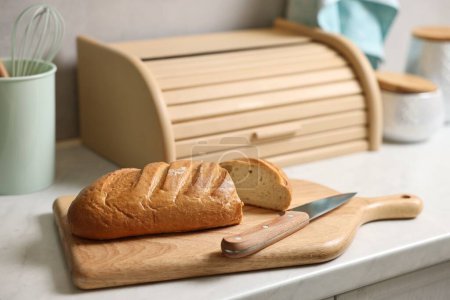 Cesta de pan de madera, pan recién horneado en la mesa de mármol blanco en la cocina