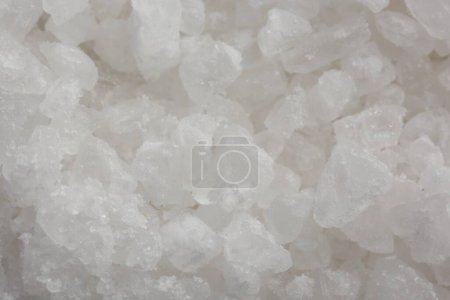 White natural salt as background, closeup view