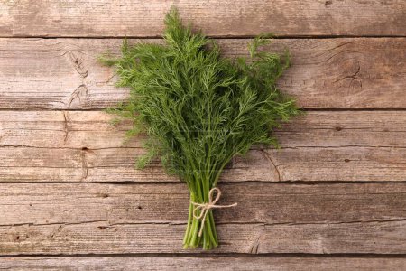 Bunch of fresh dill on wooden table, top view