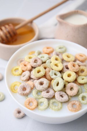 Photo for Cereal rings and milk in bowl on white table, closeup - Royalty Free Image