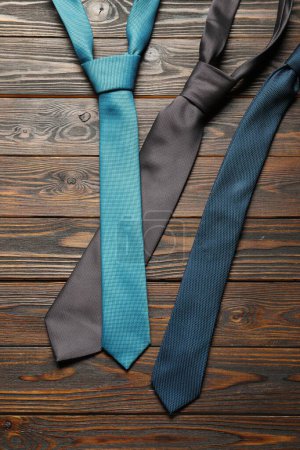 Different neckties on wooden table, flat lay