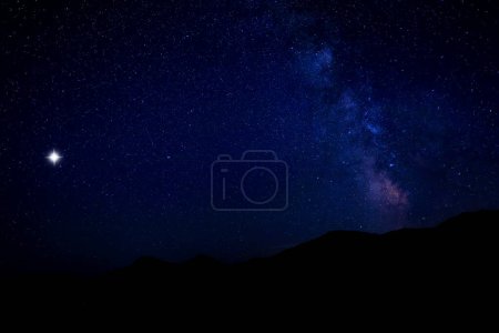Sky with twinkling stars over mountains at night