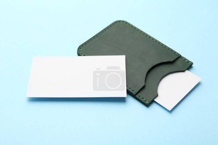 Téléchargez les photos : Porte-cartes de visite en cuir avec cartes vierges sur fond bleu clair - en image libre de droit