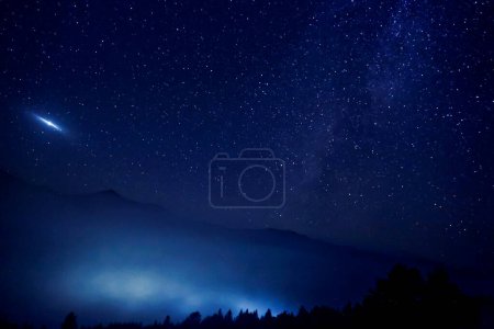 Ciel avec des étoiles scintillantes sur les montagnes la nuit