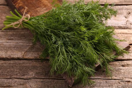 Bunch of fresh dill on wooden table, closeup