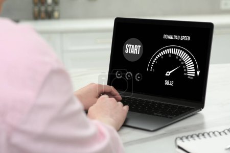 Speed test. Woman using laptop at table, closeup