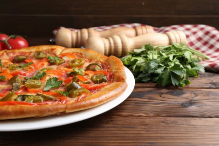 Delicious pizza Diablo and ingredients on wooden table, closeup. Space for text