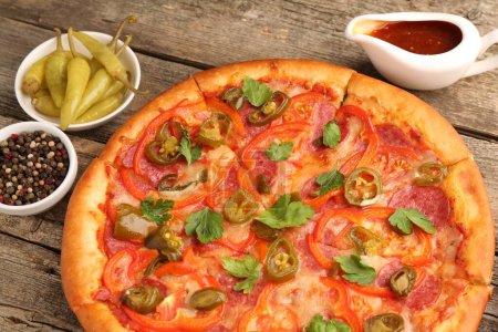 Photo for Delicious pizza Diablo and ingredients on wooden table, closeup - Royalty Free Image