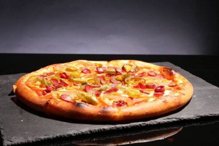 Delicious pizza Diablo on slate board against grey background