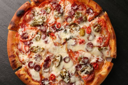 Delicious pizza Diablo on dark textured table, top view