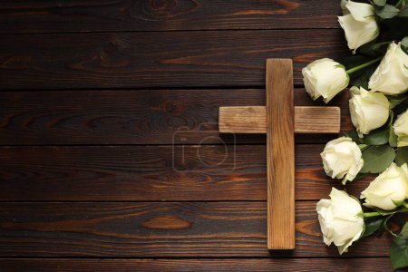 Cross and roses on wooden table, top view with space for text. Religion of Christianity
