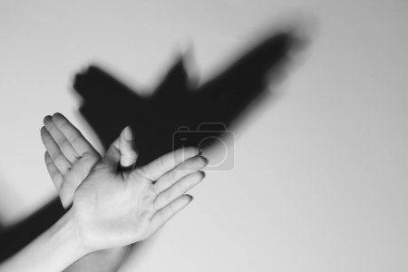 Femme faisant geste de la main comme un oiseau sur fond clair, gros plan avec de l'espace pour le texte. Effet noir et blanc